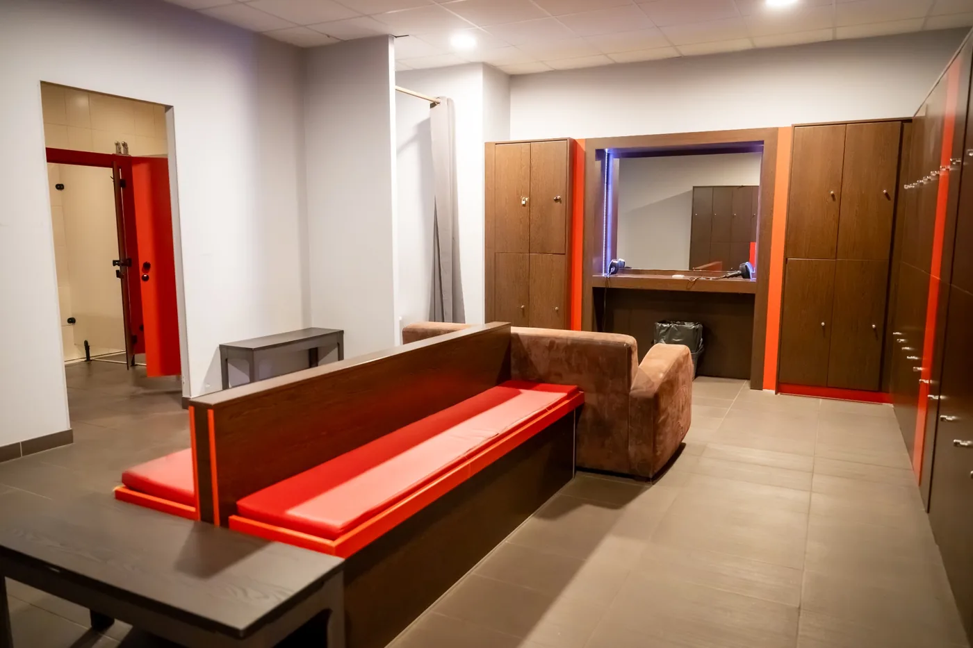 Vestiaires d'Odyssée avec casiers et bancs rouges